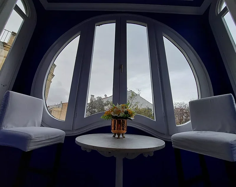 Rincón con mirador circular en el Hotel Noucentista con tapizado de terciopelo azul