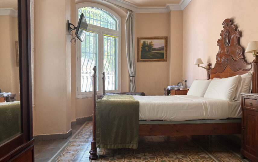 Habitación doble planta baja del Hotel Noucentista con mobiliario antiguo y suelo de mosaico