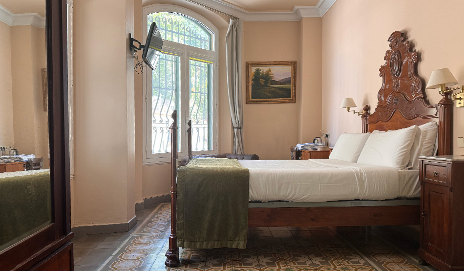 Habitación doble planta baja del Hotel Noucentista con mobiliario antiguo y suelo de mosaico