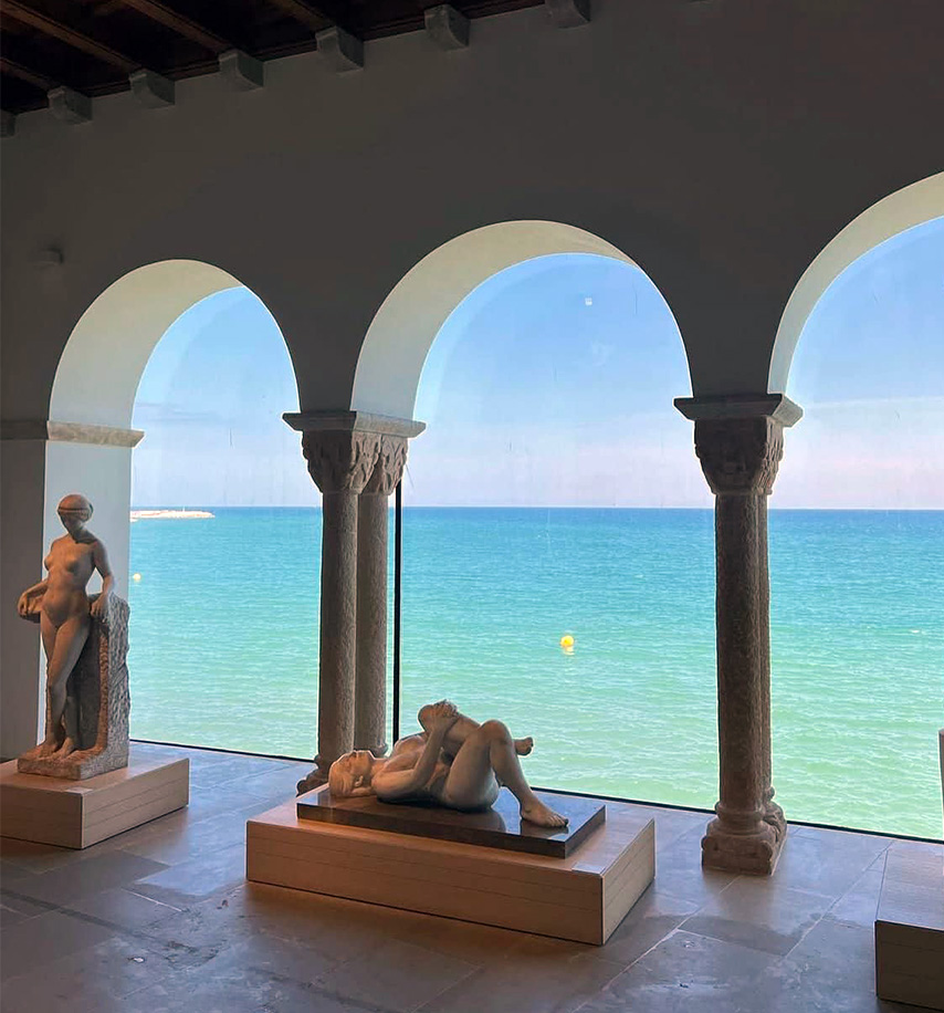 Iglesia de Sant Bartomeu i Santa Tecla en Sitges — campanario y fachada con vistas al mar