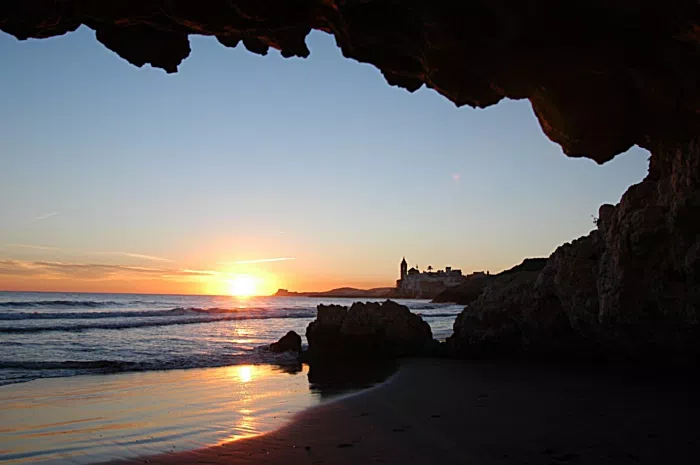 Cala Balmins en Sitges, aguas tranquilas y rocas al final del día