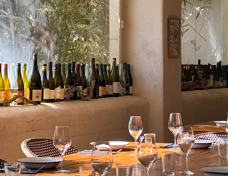 Gastraum eines Restaurants in Sitges, gedeckter Tisch vor einer Wand aus Weinflaschen