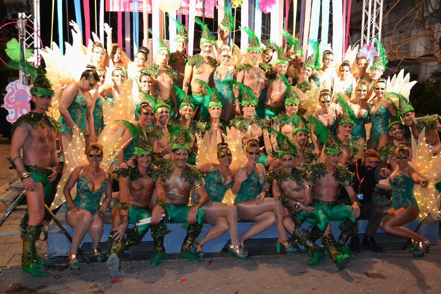 Colla disfrazada en el carnaval de Sitges, comparsa con trajes de plumas en la fiesta nocturna
