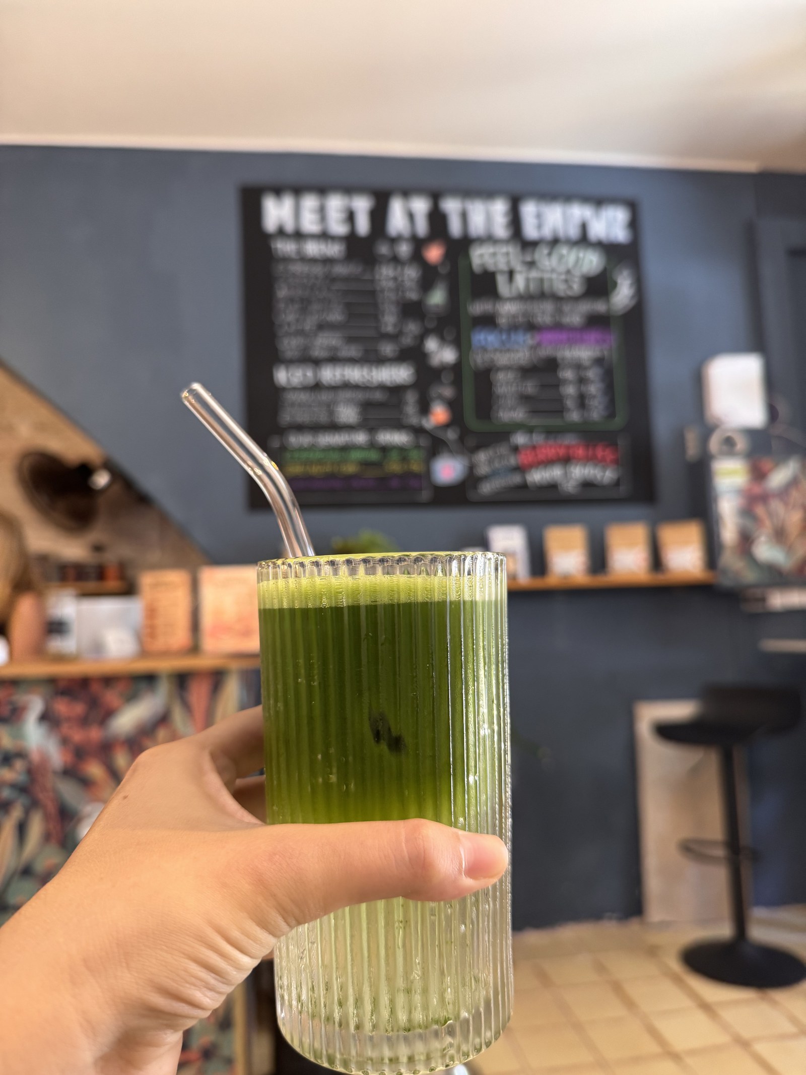 Tall ceremonial matcha in front of the feel-good lattes menu at The EMPWR in Sitges