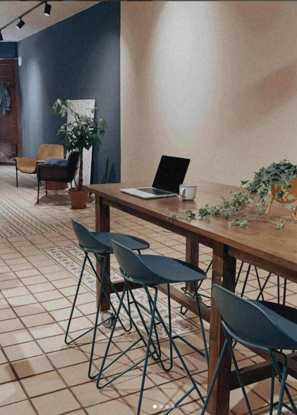 Communal work table with a laptop at The EMPWR coworking cafe in Sitges