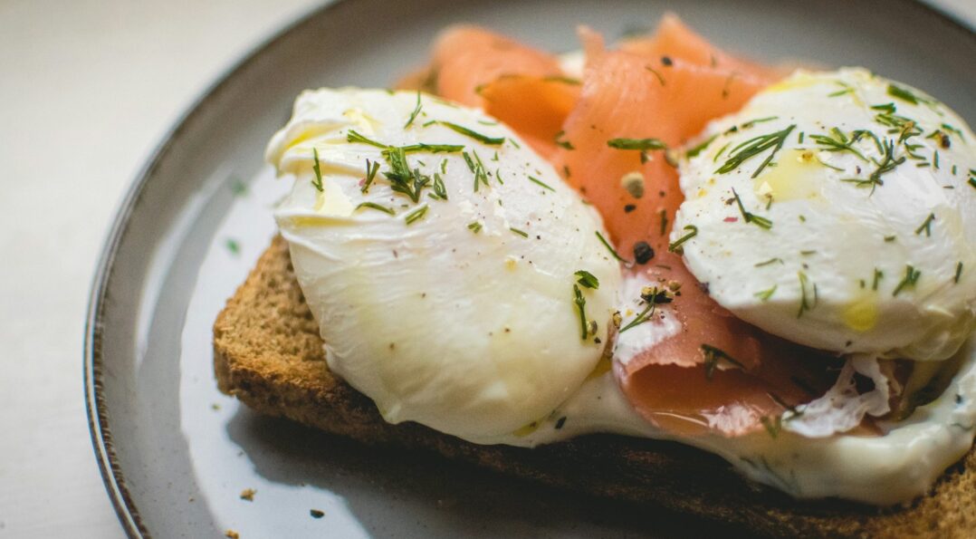 Gros plan sur des œufs pochés et une tartine de saumon pour un brunch à Sitges