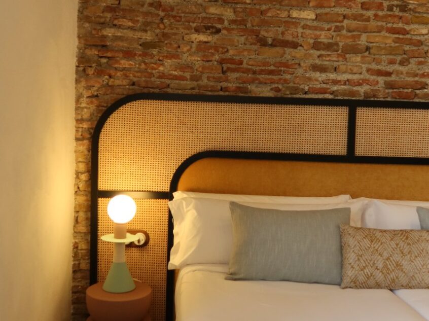 Chambre boutique au mur de brique apparente et suspensions chaleureuses, Casa Beatas