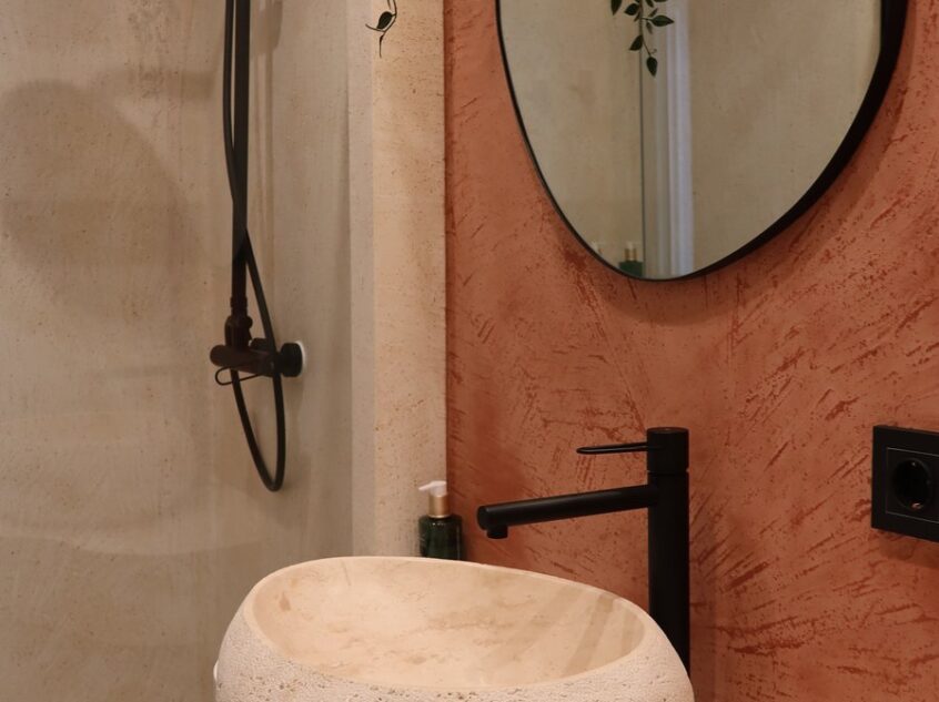 Vasque ronde en pierre sur mur terracotta, detail de salle de bain design, Casa Beatas